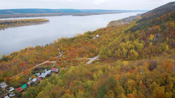 Aerial View. Autumn, a Large River Among the Forest Hills. The Trees Are Already in Yellow and