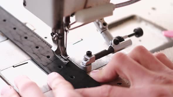 The Craftsman Stitches a Men's Leather Belt on a Sewing Machine