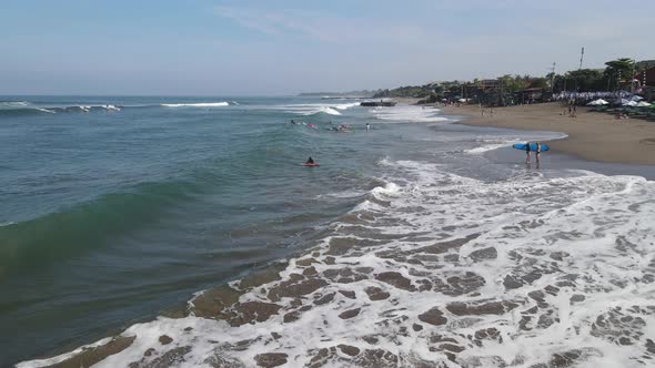 Aerial view of Canggu beach with surf people in afternoon