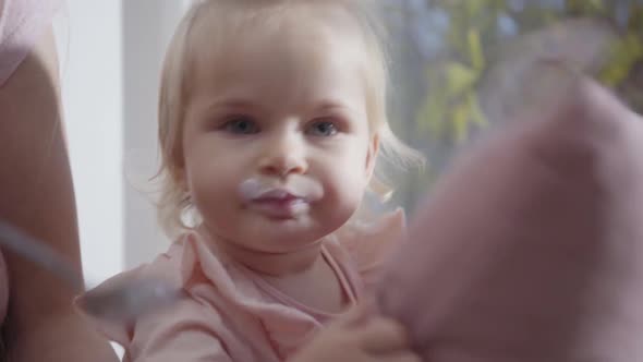 Close-up Face of Caucasian Little Girl Eating Baby Food