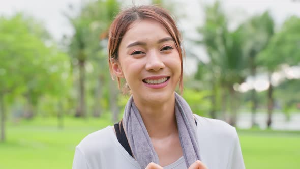 Portrait of young girl in sportswear smile, and look at camera after running workout at public park.