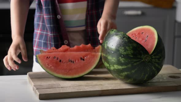 Little kid eating watermelon in kitchen