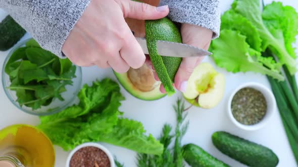 Woman Cooking Salad of Fresh Green Vegetables and Herbs