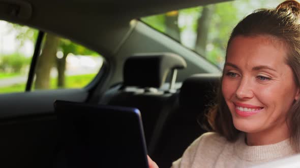 Smiling Woman in Car Using Tablet Pc Computer