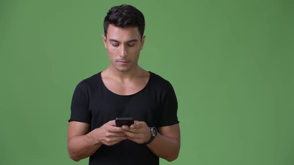 Young Handsome Hispanic Man Against Green Background