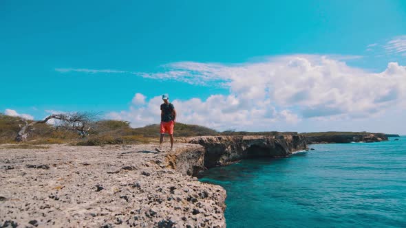 Boy walking along edge of cliffside, Curacao