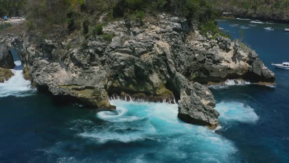 natural ocean whirlpool with waves crashing into rocks at crystal bay nusa penida island in bali, ae