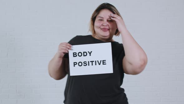Concept Body Positivity an Overweight Smiling Woman Dancing and Holds a Sign with the Inscription