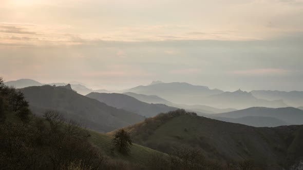 Mountains at Dawn Illuminated by the Rays of the Sun Through the Clouds.