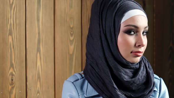 Beautiful Arab Woman in Hijab with Bright Makeup Looks in Front of a Camera.