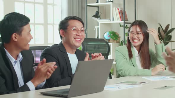 Young Asian Team Have Meeting In A Conference Room. They're Happy And Celebrate With Clapping Hands