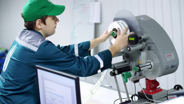 CHERKASY UKRAINE AUGUST 24 2018 the Worker Changes Paper Roll with Marking Stickers on a Machine