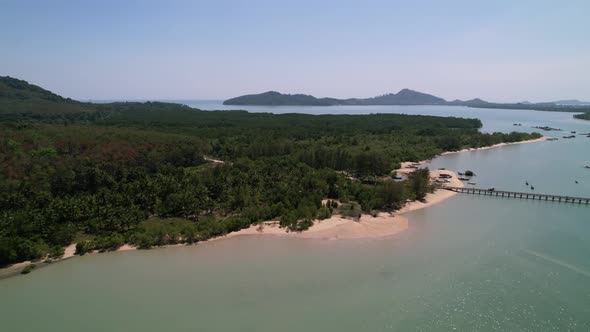 small white sand beach near pier on coconut island in phuket thailand, aerial