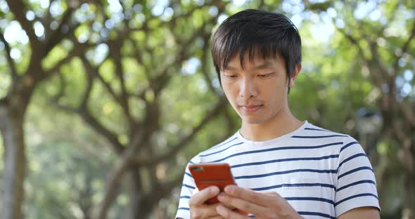 Young Man Use of Mobile Phone at Outdoor