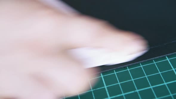 Person Hand Wipes White Line on Leather with Black Napkin