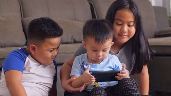 Asian Sister And Brothers Watching With Phone