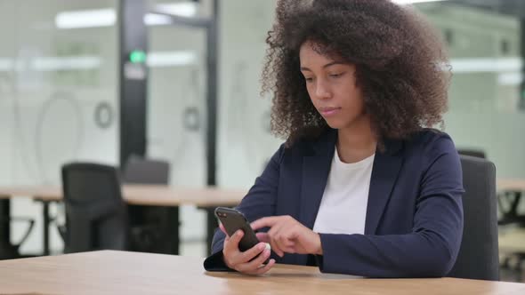 Serious Young African Businesswoman Using Smartphone