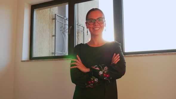 Woman with Glasses in Modern Office Workspace Looking on Camera