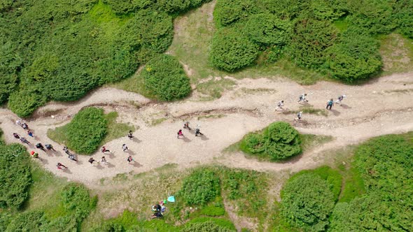 Aerial View of a Group of Young Hikers Walking Along a Mountain Path to the Top of the Mountain