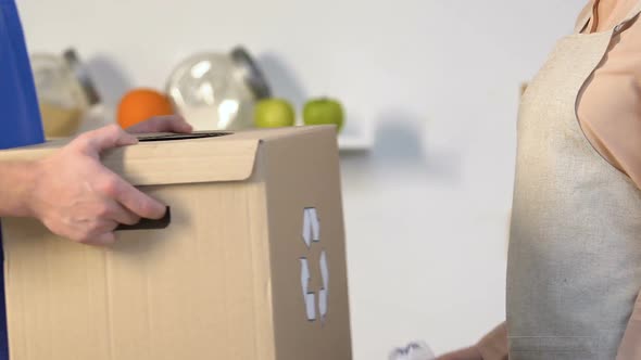 Lady Throwing Plastic Bottle Into Special Box With Recycling Sign in Mans Hands