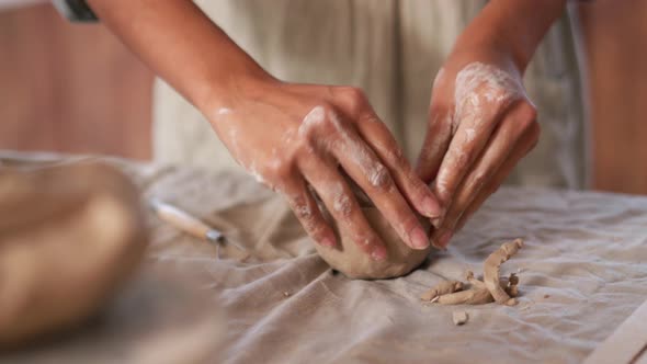 Woman potter smoothing the walls of the clay bowl