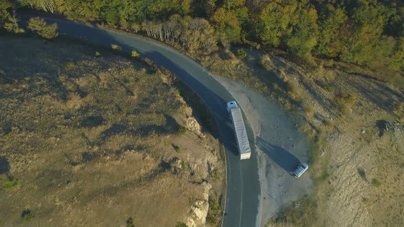 Top View of Truck on the Road. Big Logistic Lorry Driving Along Mountain Road in the Forest