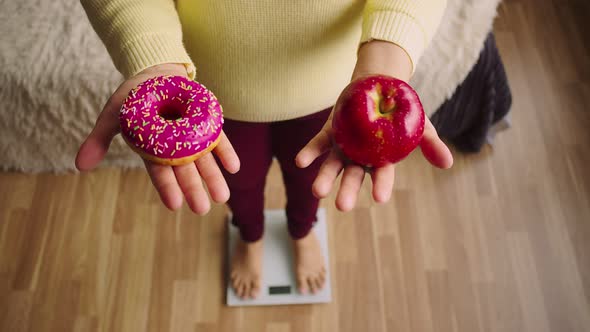 Woman Stands on the Scales and Holds an Apple with a Doughnut View From Above