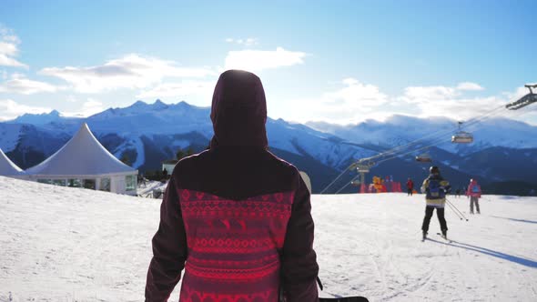 A Young Woman on a Snowboard on Top Mountain on a Ski Track