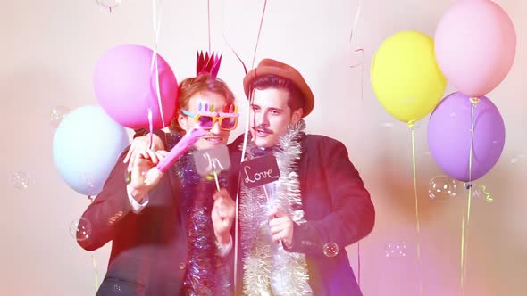 Two men holding boards in love in photo booth