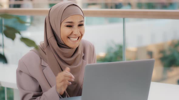 Happy Young Arab Woman Sitting at Desk Receiving Email on Laptop with Good News Shocked Excited Girl