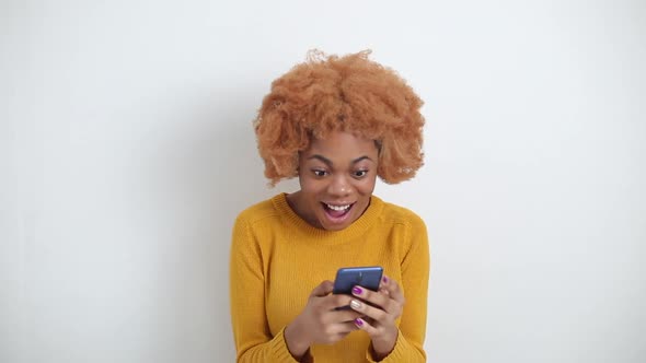 Portrait a beautiful shocked young African woman using mobile phone