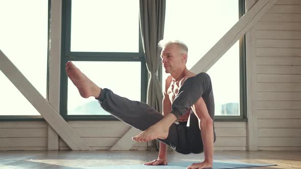 Mature Man Amongst Doing Power Yoga Exercises