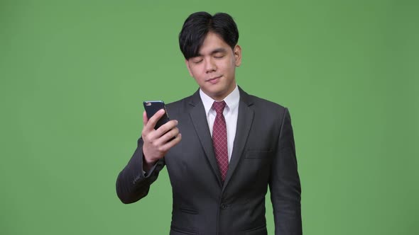 Young Handsome Asian Businessman Using Mobile Phone