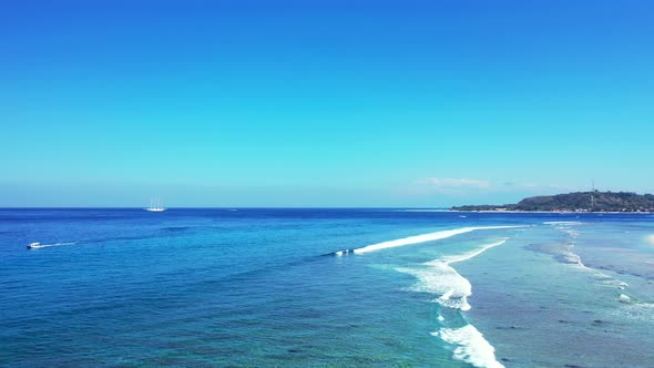 Peaceful seascape with endless blue ocean and shallow turquoise lagoon with white waves foaming over