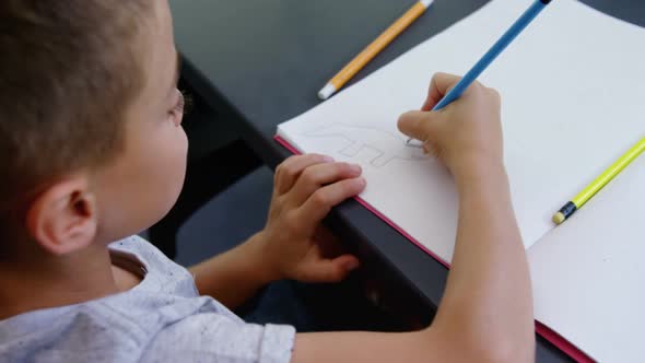 Boy drawing in book