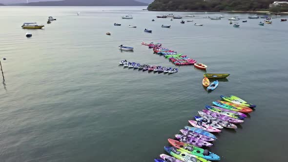 A dynamic orbiting aerial footage of various boats and kayaks near the beach of Sai Kung town in Hon