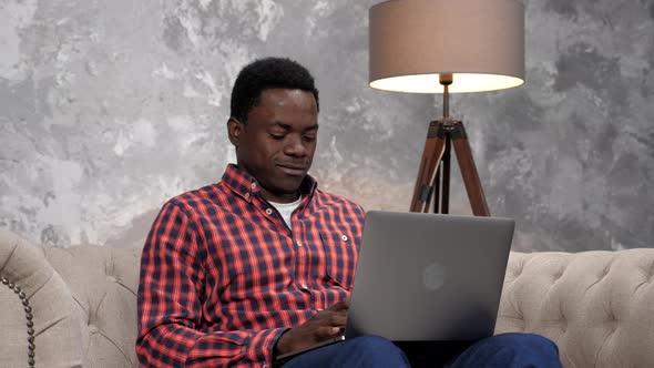 Smiling African American Businessman Works for Laptop Chatting with Employees