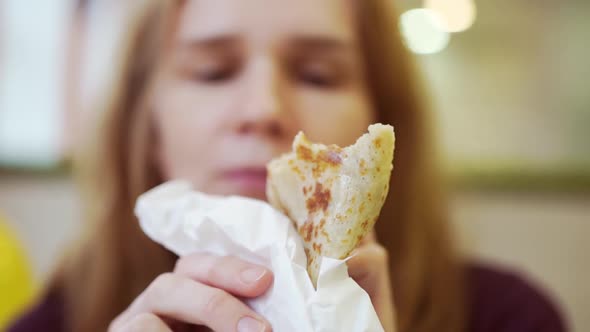 a Woman Eats a Stuffed Pancake in a Cafe