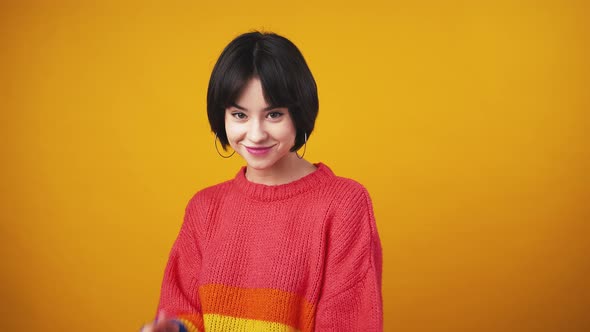 Young Playful Lady Wearing Red Sweater Turning to Camera and Pointing with Fingers Showing Gotcha