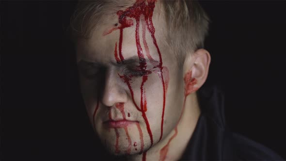 Halloween Man Portrait. Guy with Dripping Blood on His Face. Scary Makeup