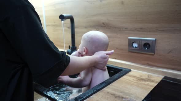 Baby in Kitchen Sink Bathing and Playing with Water