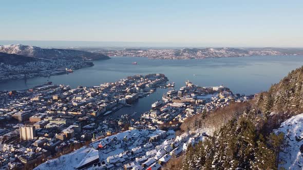 Aerial shot over Bergen Cityscape from hillside mountain with snow - Norway