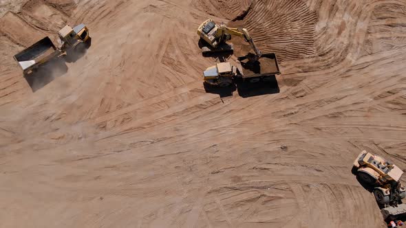 Excavator Loading Sand Into Large Truck Aerial View