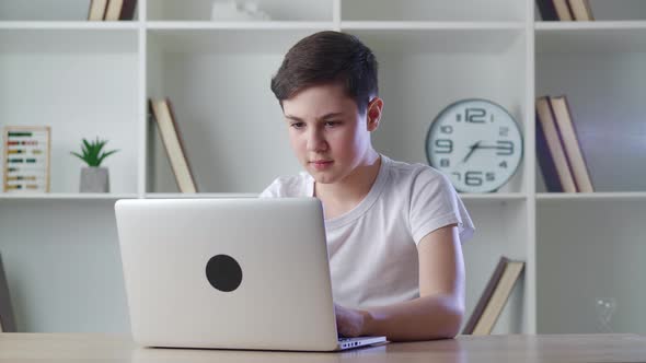 Scared Boy Shocked By Terrible Scene While Reading Horror News on Computer