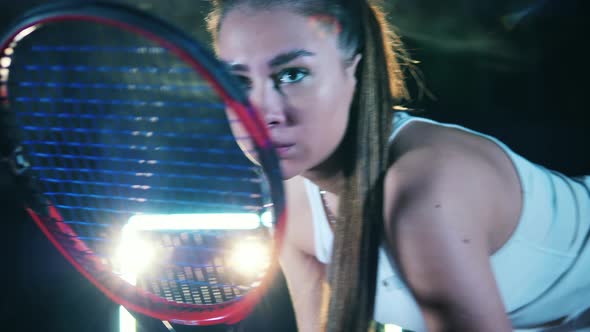 Woman s Face Seen Through a Tennis Racket in Her Hands