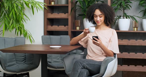 Black Business Woman Young Beautiful Curly Girl Drinking Coffee From White Cup Enjoying Cocoa