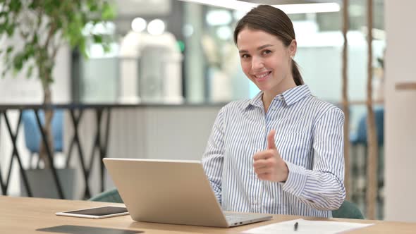 Positive Young Woman with Laptop Doing Thumbs Up