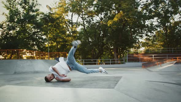 Young Male is Spinning on His Back Performing Windmill Movement While Breakdancing on Pump Track of