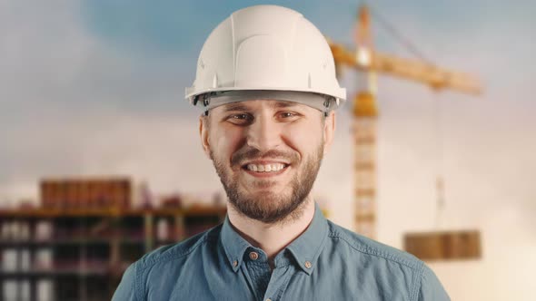 A Builder is Looking to Camera and Smiling Happily at Building Site alt