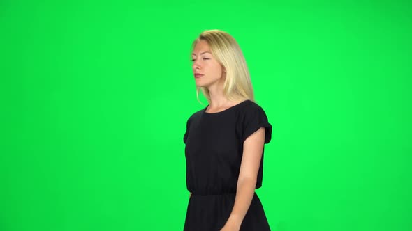 Pensive Girl Is Walking on a Green Screen at Studio